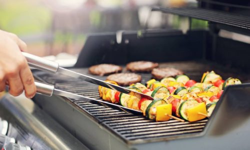 Closeup-of-Person-Grilling-Kebobs-and-Burgers-min